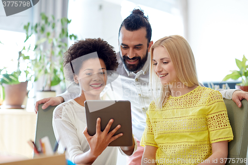 Image of happy creative team with tablet pc in office