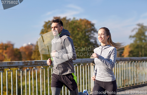 Image of happy couple running outdoors