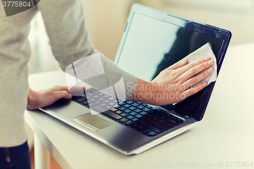 Image of close up of woman hands cleaning laptop screen