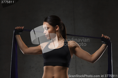 Image of woman with expander exercising in gym