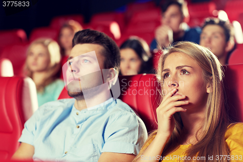 Image of happy friends watching horror movie in theater