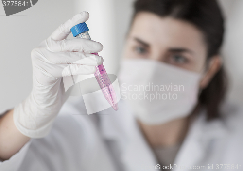 Image of close up of scientist with tube making test in lab