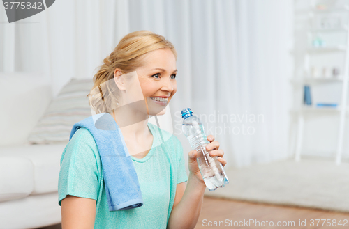 Image of happy woman drinking water and exercising at home
