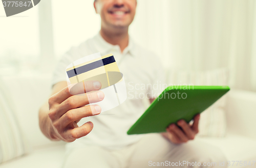 Image of close up of man with credit card and tablet pc