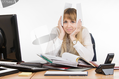 Image of Business woman buried in paper documents