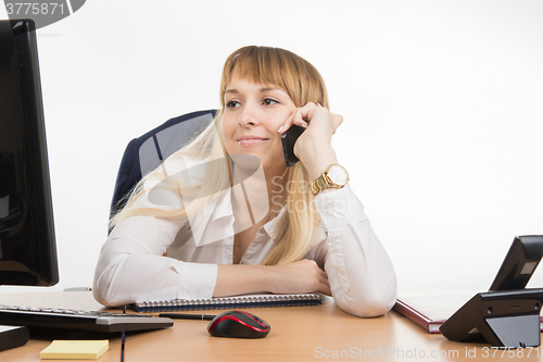 Image of Business woman happy talking on cell phone and looking at the monitor screen