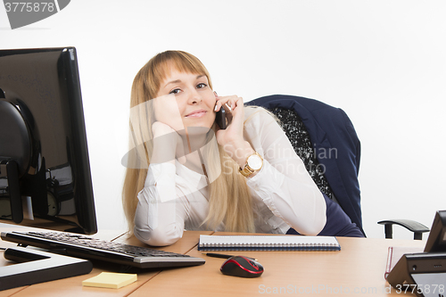 Image of Happy business woman talking on a cell phone in the office