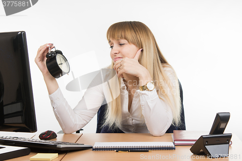 Image of Office employee sadly looks at the clock with time nine oclock five minutes in the morning