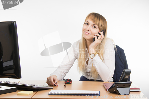 Image of Office Specialist talking on a cell phone in the workplace