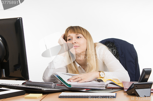 Image of Office work tired a specialist to sort out folders with documents and looked sadly at the monitor screen