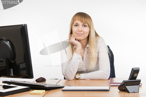 Image of Business woman sitting at a desk in the office and looking at the frame