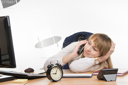 Image of Not enough sleep office employee at his desk answers the phone