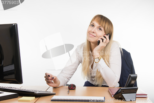 Image of Office Specialist talking on a cell phone in the workplace