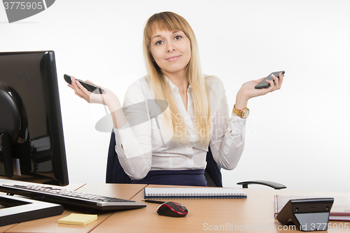 Image of Secretary holding two phone rang - and mobile working