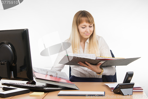 Image of Tired secretary found the right document in a folder and smiling