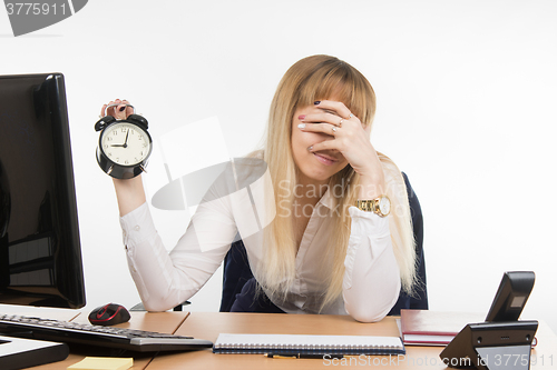 Image of Office employee covered her face with his hand from the unwillingness to work