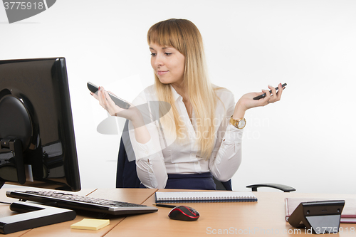 Image of Secretary holding two phone rang and looked at work