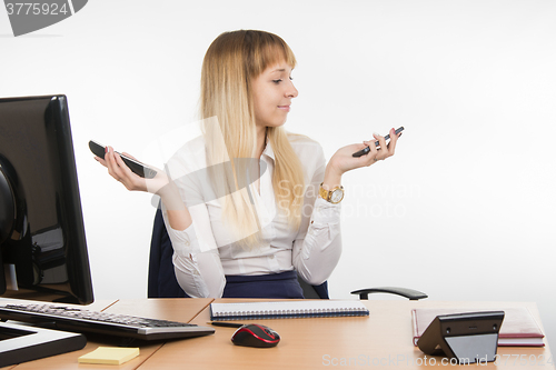 Image of Secretary holding two phone rang and looked at mobile