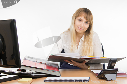 Image of Office a specialist wearily leafing through a folder with documents