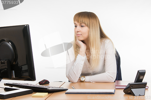 Image of Business woman looking at a computer monitor at the table in the office