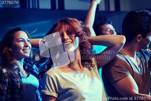 Image of happy friends dancing at night club