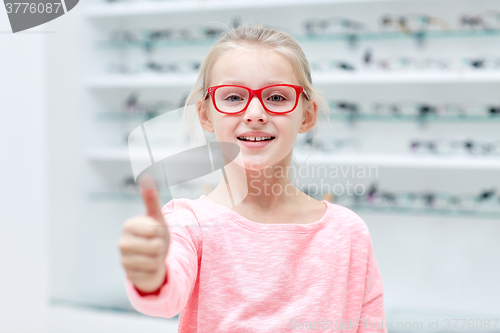 Image of girl in glasses at optics store showing thumbs up