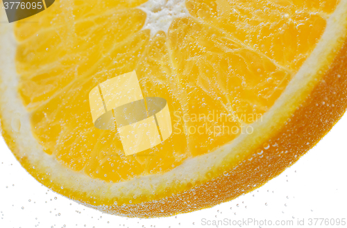 Image of orange slice falling or dipping in water 