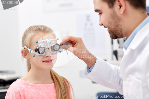 Image of optician with trial frame and girl at clinic