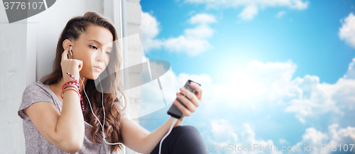 Image of teenage girl with smartphone and earphones