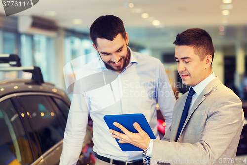 Image of happy man with car dealer in auto show or salon