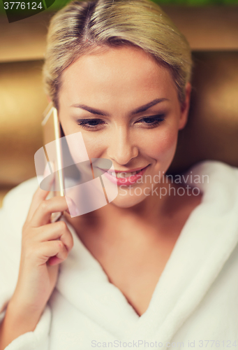 Image of beautiful young woman with smartphone at spa