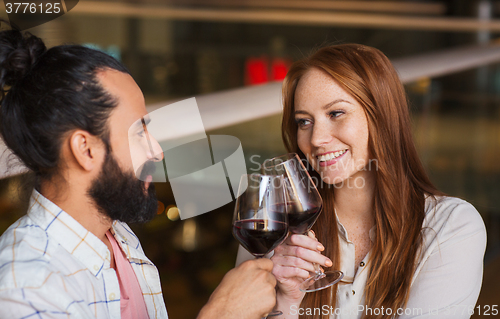Image of couple drinking red wine and clinking glasses