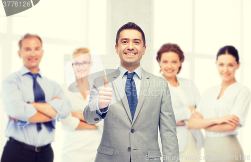 Image of happy businessman in suit showing thumbs up
