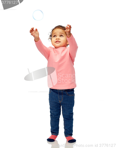 Image of little baby girl playing with soap bubble