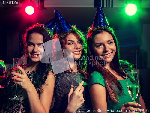 Image of smiling friends with glasses of champagne in club