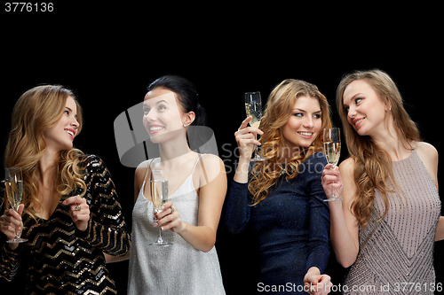 Image of happy women with champagne dancing over black