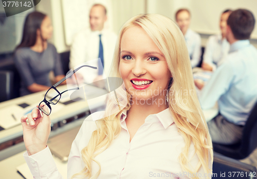 Image of smiling businesswoman or secretary in office