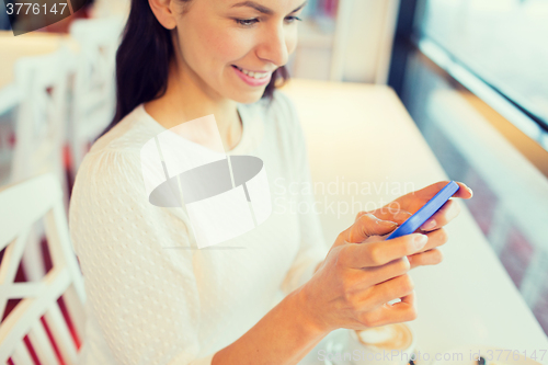 Image of close up of woman with smartphone at cafe