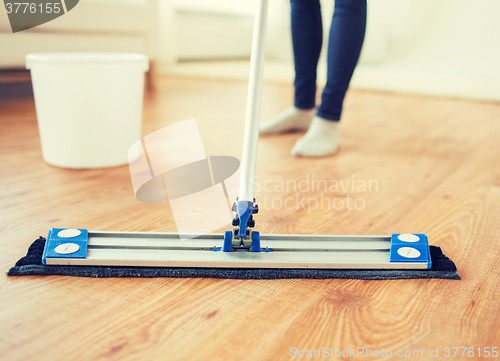 Image of close up of woman with mop cleaning floor at home