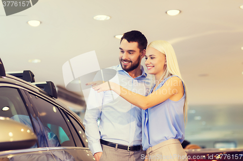 Image of happy couple buying car in auto show or salon