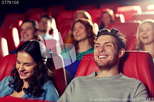 Image of happy friends watching movie in theater