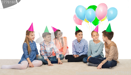 Image of happy smiling children in party hats on birthday