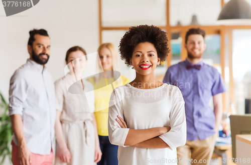 Image of happy young woman over creative team in office