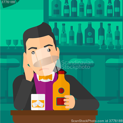 Image of Sad man with bottle and glass.