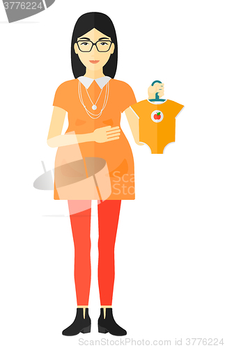 Image of Pregnant woman with clothes for baby.