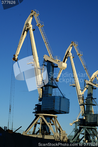 Image of Image of an industrial port large cranes against blue sky