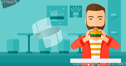 Image of Man eating hamburger. 