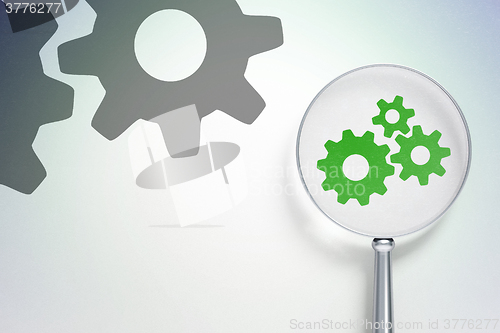 Image of Web development concept:  Gears with optical glass on digital background