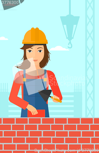 Image of Bricklayer with spatula and brick.