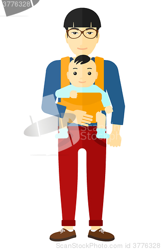 Image of Man holding baby in sling.